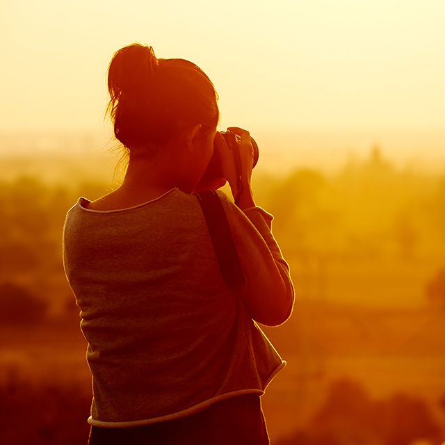 female traveller photographing temples at Bagan Myanmar Asia at sunrise