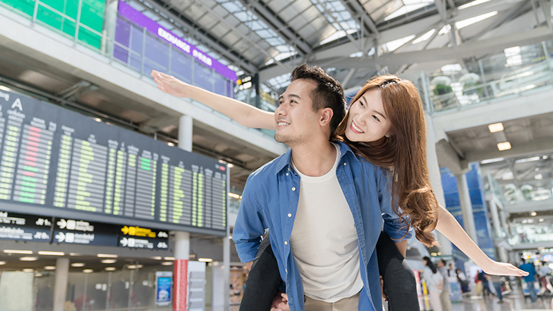 Happy young asian couples traveler having fun at airport terminal. Travel and lover concept.